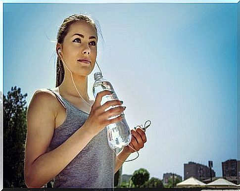 Girl with headphones and bottle of water