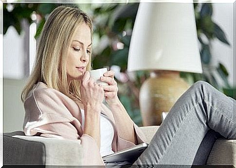 Seated woman drinks infusion against headache