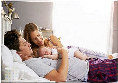 Newborn baby sleeping with his parents