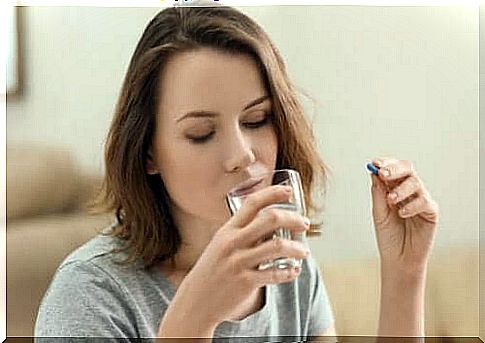 Woman with glass of water and pill