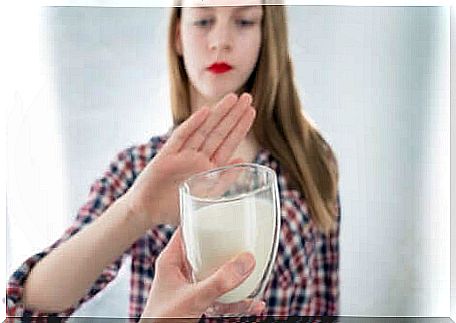 Woman refusing a glass of milk.