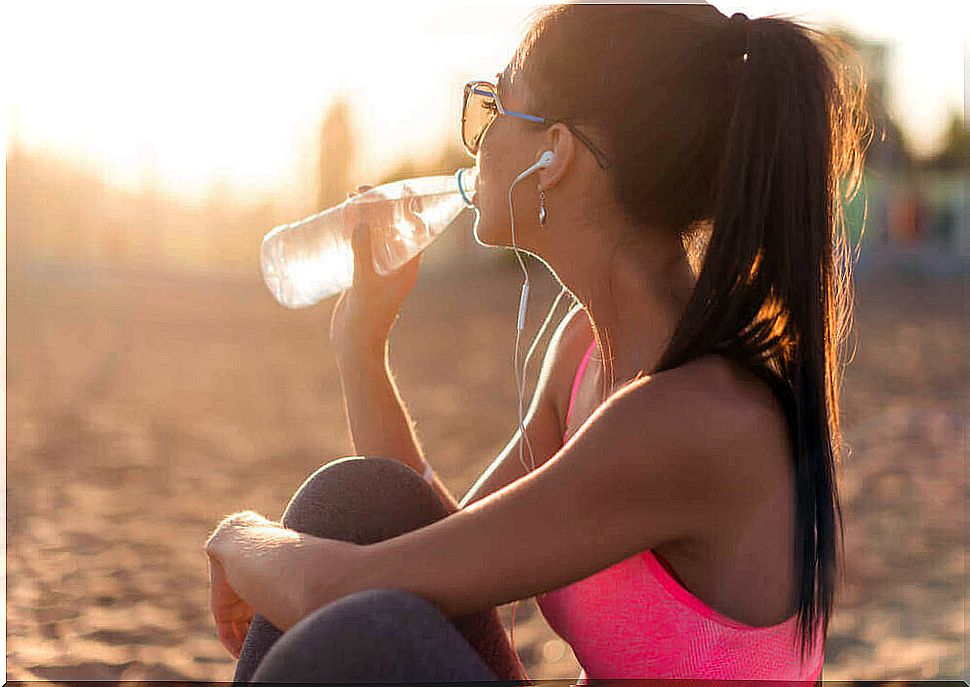 Girl drinks water from a bottle