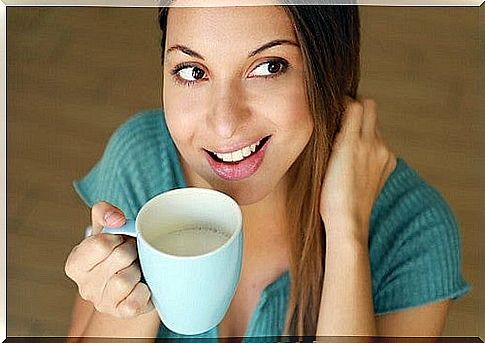 Young man drinks a cup of milk.