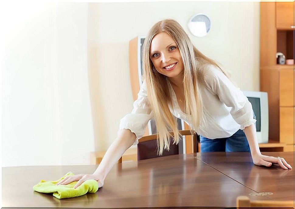 Woman wipes the table with a cloth