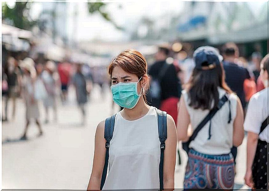 Woman with mask in crowded street