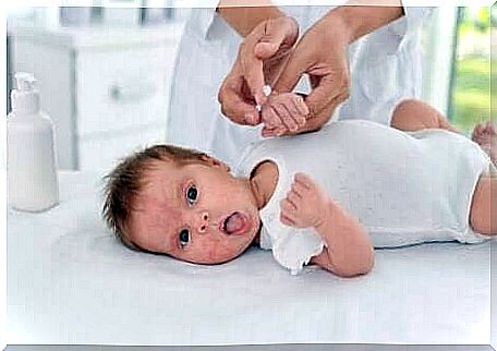 Infant in swaddling clothes with atopic dermatitis.